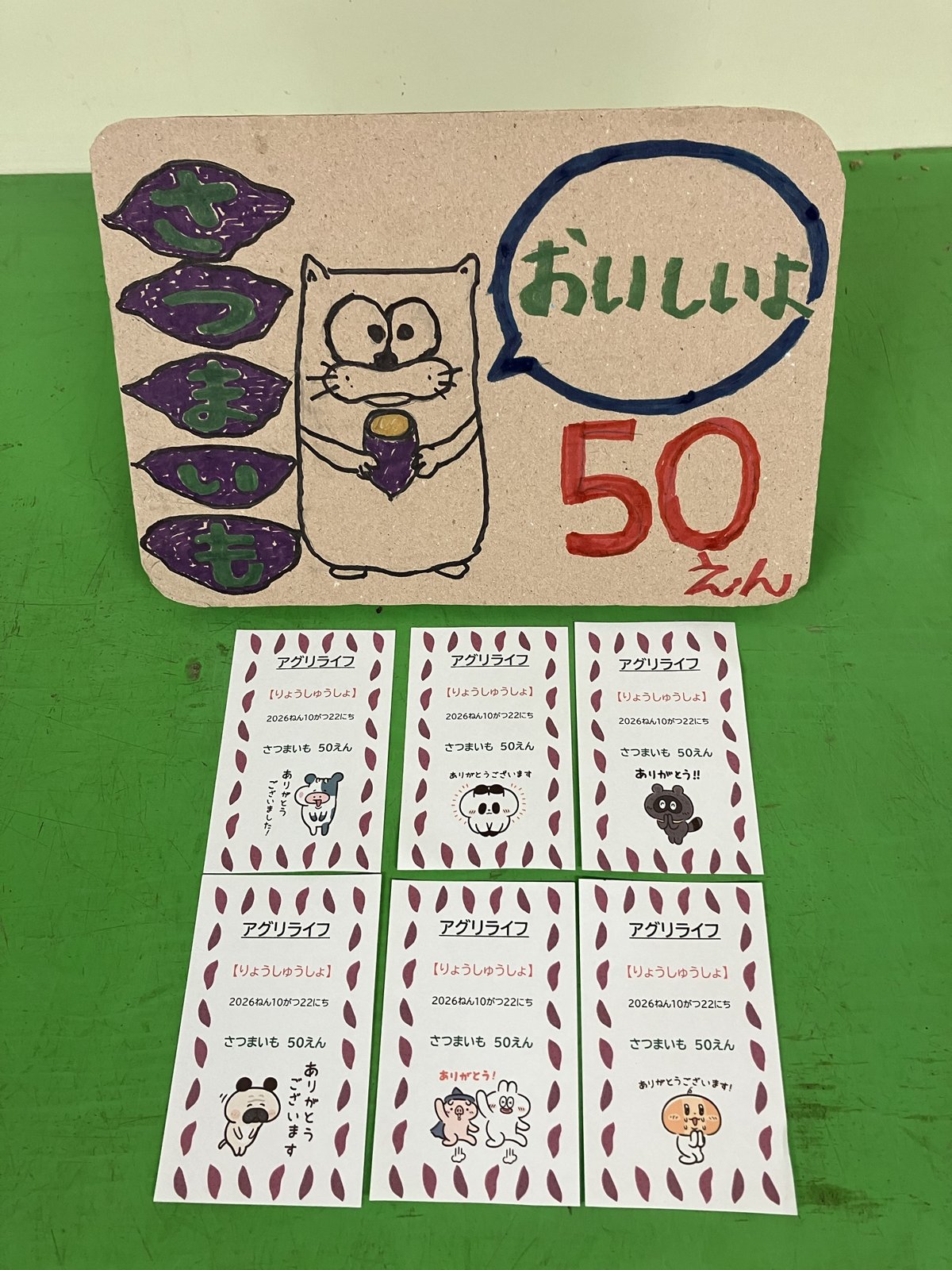 「さつまいも おいしいよ 50えん」の手描き看板と、ひらがなで書かれた子ども向けの領収書